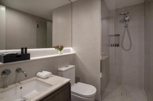 a bathroom with a shower and a toilet and a sink at Oakwood Premier Melbourne in Melbourne