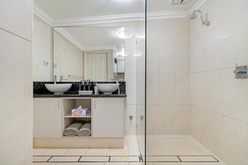 a bathroom with two sinks and a shower at Point Samson Resort in Point Samson