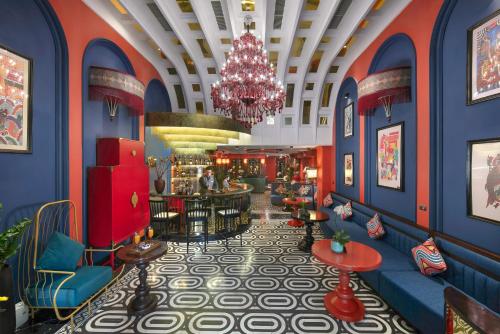 un hall d'un hôtel disney avec des murs bleus et un lustre dans l'établissement HOTEL du LAC Hanoi, à Hanoï