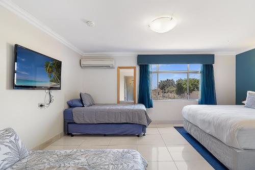 a hotel room with two beds and a window at Point Samson Resort in Point Samson