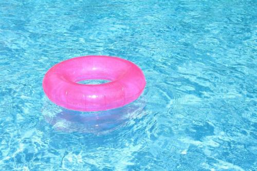 Różowe frisbee pływające w basenie w obiekcie The Sato hotel w mieście Kudus