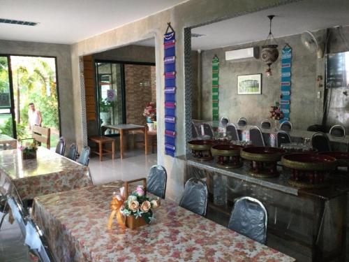 a restaurant with tables and chairs in a room at Pimlada in Chiang Mai