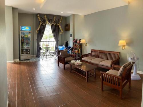 uma sala de estar com um sofá, cadeiras e uma mesa em Thong Prachok Hotel em Sakon Nakhon