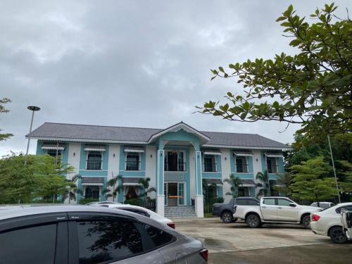 niebieski dom z samochodami zaparkowanymi na parkingu w obiekcie Thong Prachok Hotel w mieście Sakon Nakhon