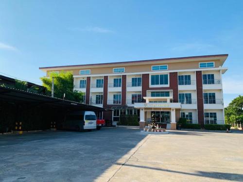 ein großes Gebäude mit einem Parkplatz davor in der Unterkunft นิวธาราเพลส หล่มสัก โรงแรม in Ban Nam Phung
