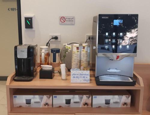 Ceniq Hotel في Ban Long: كونتر به آلة صنع القهوة وكمبيوتر محمول
