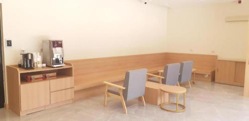 Zimmer mit 3 Stühlen, einem Tisch und einer Kaffeemaschine in der Unterkunft Ceniq Hotel in Ban Long