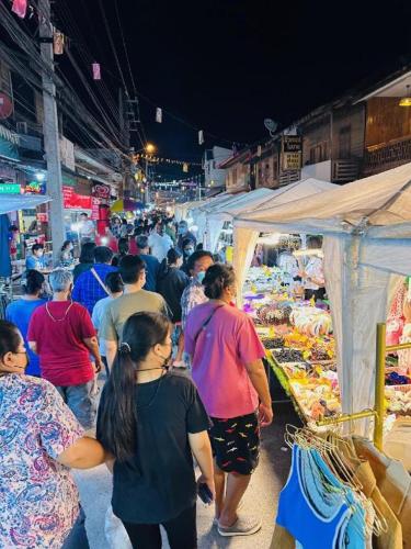 a crowd of people walking through a market at night at Niwtara Place Lom Sak Hotel in Phetchabun