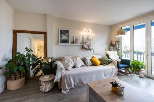 sala de estar con sofá y mesa en Appartement cosy et lumineux-parking gratuit- proche de Paris en LʼHay-les-Roses