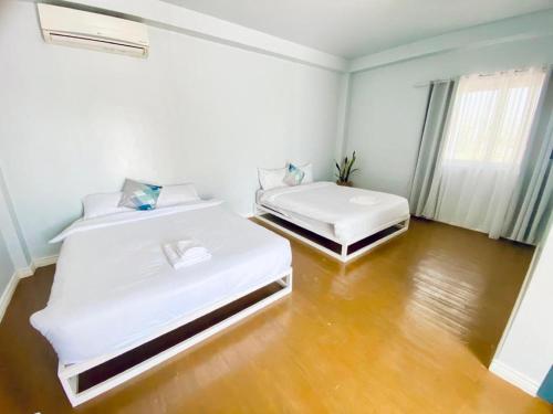 Habitación con 2 camas individuales y suelo de madera. en THE SHORELINE SUBIC HOTEL, en Olóngapo