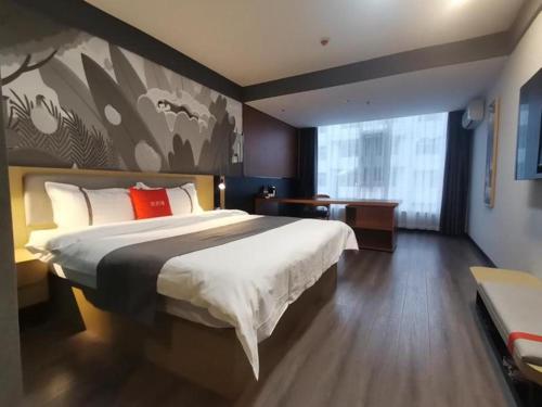 a bedroom with a large bed with a large painting on the wall at Thank Hotel Shanxi Lvliang Zhongyang County North Fengcheng Street in Zhongyang