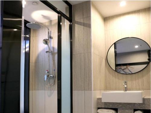 een badkamer met een douche, een wastafel en een spiegel bij Thank Hotel Shanxi Lvliang Zhongyang County North Fengcheng Street in Zhongyang