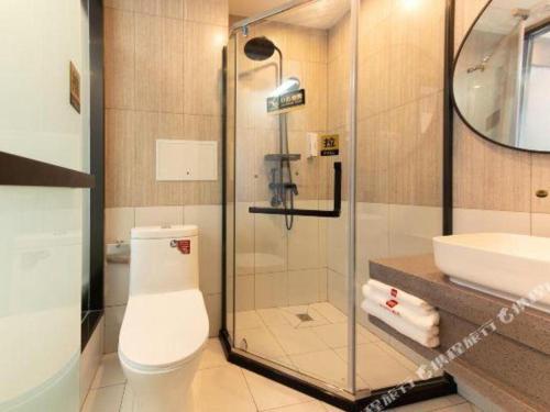 een badkamer met een douche, een toilet en een wastafel bij Thank Hotel Hebei Cangzhou Wuqiao County Acrobatics World in Wuqiao
