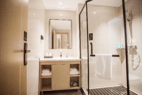 a bathroom with a sink and a shower at City Comfort Inn Luzhou Jiangyang District Wancheng International in Luzhou