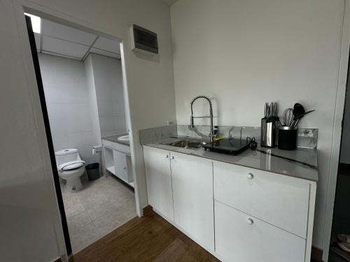 a white kitchen with a sink and a toilet at View Talay6 by Blue Ocean Suite in Pattaya Central