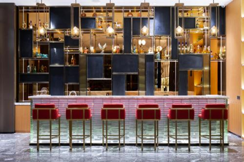 a bar with red chairs in a room at JOYCHENG Hotel Wuhan Hanyang Avenue Guobo in Han-yang-hsien