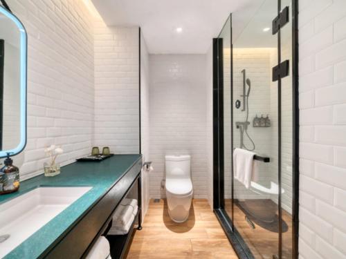 a bathroom with a sink and a toilet and a shower at Premier City Comfort Hotel Xuzhou Suning Square in Xuzhou
