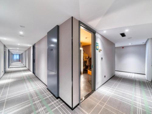 a corridor of an office building with glass doors at Premier City Comfort Hotel Xuzhou Suning Square in Xuzhou