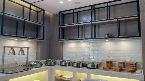 kuchnia z garnkami i patelniami na ladzie w obiekcie Echarm Hotel Yantai Wuzhou International w mieście Fushan