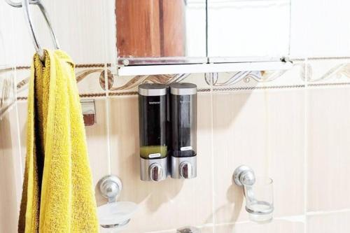 a bathroom with a soap dispenser and a yellow towel at Sientete como en casa. in El Seis