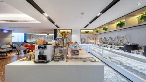 a store with a counter with food on display at Echarm Hotel Wuzhou Wangcheng Plaza Longmumiao Sanzongfu in Wuzhou