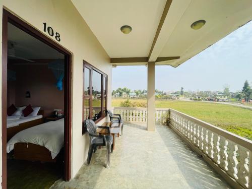 a balcony of a bedroom with a bed and a view at Hotel Tree Tops in Sauraha