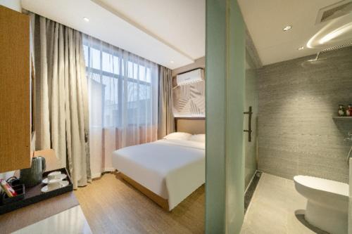 เตียงในห้องที่ Borrman Hotel Xiantao Wushang Gymnasium