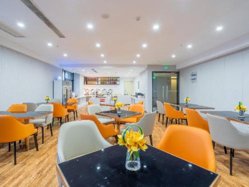 a restaurant with tables and chairs and yellow chairs at Echarm Hotel Wuhu Wanzhi East Lake Yingbin Avenue in Liangzhongchang