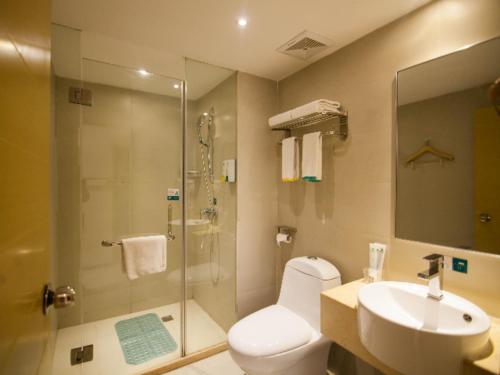 a bathroom with a shower and a toilet and a sink at City Comfort Inn Yichang Wanda Plaza Yunhe Park in Baiyang