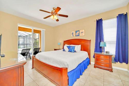 a bedroom with a bed and a ceiling fan at Near Disney 7BR Home - Pool Hot Tub Games Room in Kissimmee