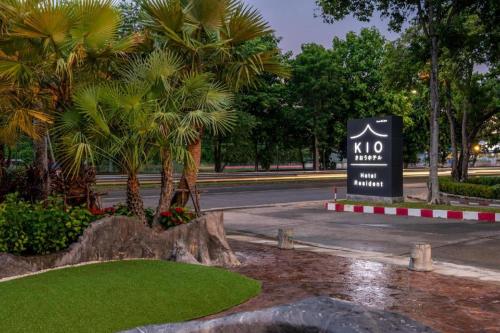 uma placa no meio de uma rua com palmeiras em Kio Hotel Korat em Ban Hua La Loeng