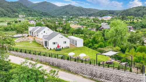 uma vista aérea de uma casa branca numa colina em Seorak Jaeins Garden em Yangyang