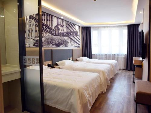 a hotel room with three beds and a bathroom at Super 8 Hotel Urumqi West Wuyi Road in Ürümqi