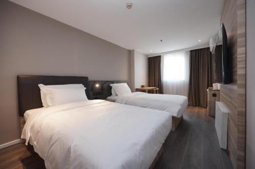 Una cama o camas en una habitación de Hanting Hotel Beijing Xisanqi Dongsheng Technology Park