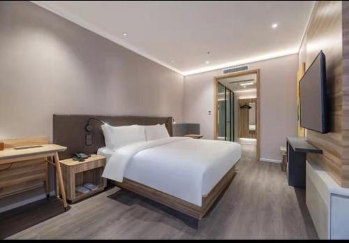 سرير أو أسرّة في غرفة في Hanting Hotel Jinan Gangxi Road Free Bonded Area
