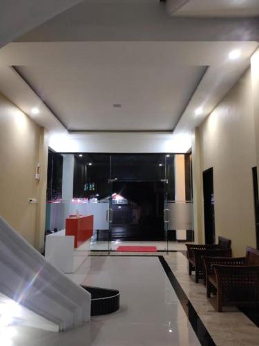 Arro hotel bukittinggi (syariah) في Gadut: لوبي وكراسي وغرفة كبيرة مع مبنى
