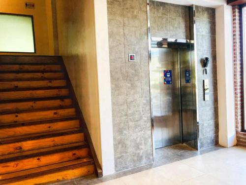 um elevador num edifício com escadas de madeira em Mango Valley Hotel 5 em Olongapo
