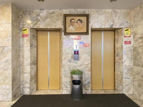 Dos ascensores en un edificio con una foto en la pared en โรงแรมไทยโฮเต็ล en Nakhon Si Thammarat