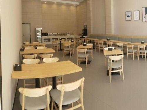 ein Klassenzimmer mit Tischen und Stühlen in einer Cafeteria in der Unterkunft Green Tree Inn Liaoning Panjin Wanda Plaza Tianjia in Panjin