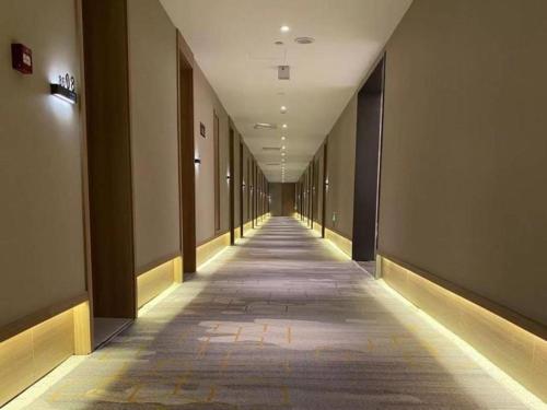 un corridoio vuoto di un edificio con lungo corridoio di Green Tree Inn Shache County Lvcheng Times Plaza a Shache
