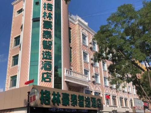 um edifício com um sinal em frente em Green Tree Inn Gansu Tianshui Qinzhou District Tianshui Wanda Plaza em Tianshui