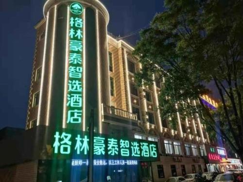 un edificio con una señal verde en el costado. en Green Tree Inn Gansu Tianshui Qinzhou District Tianshui Wanda Plaza en Tianshui