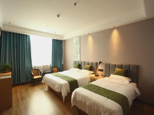 a hotel room with two beds and a window at Green Tree Inn Shandong Dongying Lijin County Phoenix Plaza in Litsinghsien