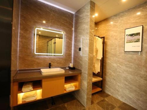 a bathroom with a sink and a mirror at Green Tree Inn Shandong Dongying Lijin County Phoenix Plaza in Litsinghsien