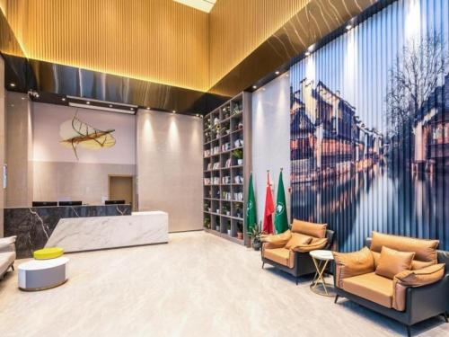 a lobby with couches and a wall with a picture at Green Tree Inn Suzhou Wujiang East Tai Lake Tourism Resorts in Hubin