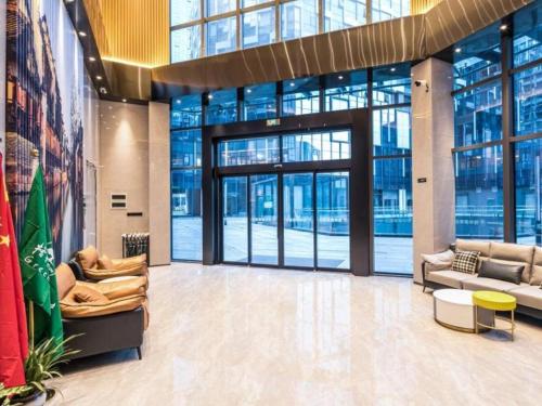 a lobby with couches and tables in a building at Green Tree Inn Suzhou Wujiang East Tai Lake Tourism Resorts in Hubin