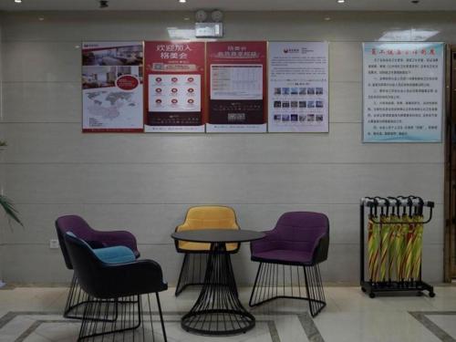 stół i krzesła przed ścianą w obiekcie Shell Hotel Anhui Liuan Jinan District Zhengyang Road w mieście Chengdong