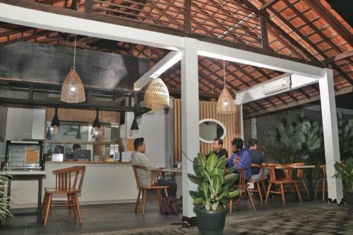 De Jati House في Cibening Empat: مجموعة من الناس يجلسون على طاولة في مطعم