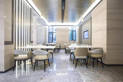 a dining room with white tables and chairs at Atour Hotel Shenyang Heping Street Dongbei University in Shenyang