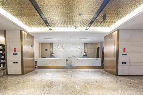 un vestidor grande con dos hombres en el espejo en Atour Hotel Shenyang Heping Street Dongbei University en Shenyang